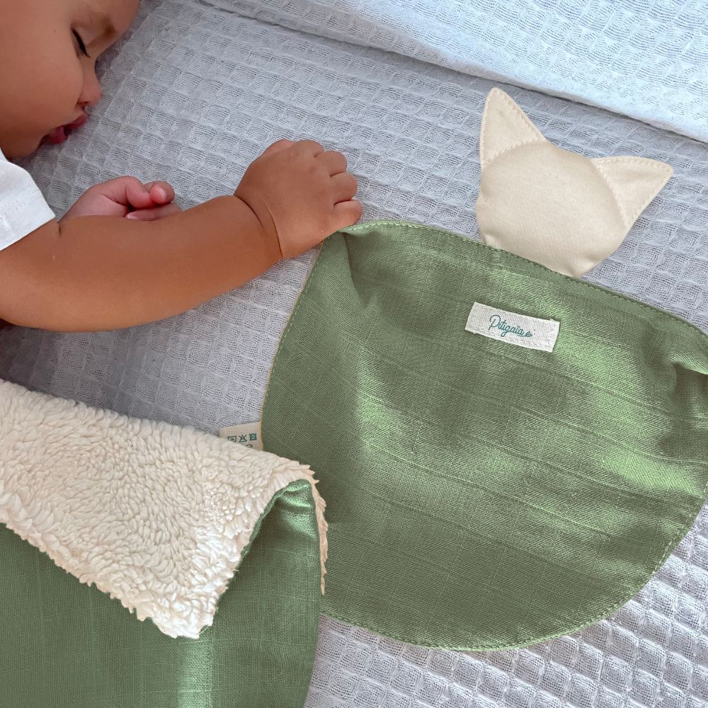 photo d'un bébé qui dort en tenant un doudou plat bio