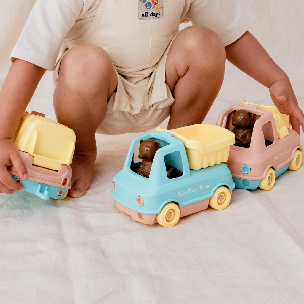 enfant jouant avec le camion benne de petit ours brun
