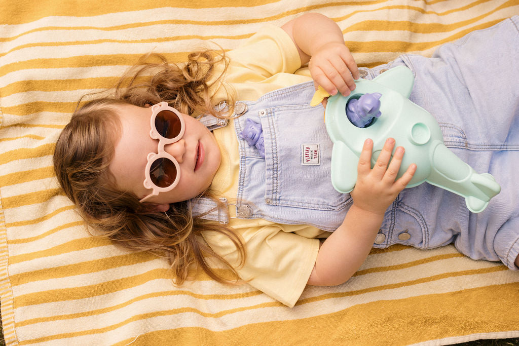 photo lifestyle en exterieur d'une petite fille tenant un Hydravion bateau made in france