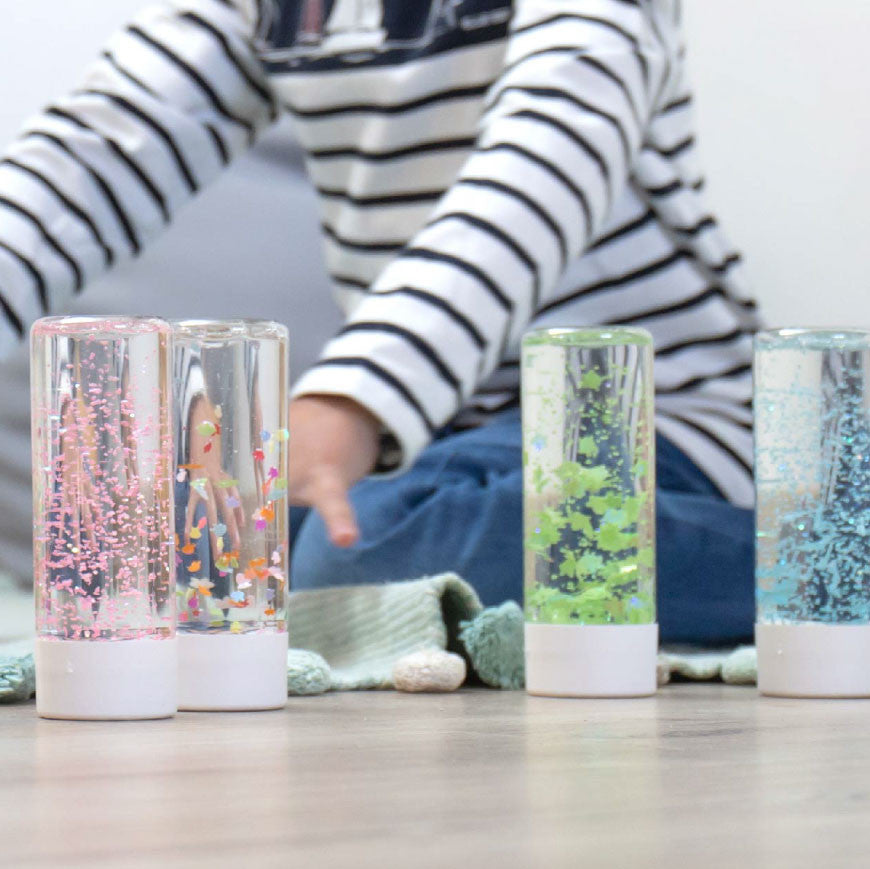 photo d'un enfant jouant avec des bouteilles sensorielles
